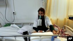 An Afghan patient who infected with COVID-19 sits on a bed in the intensive care unit of the Afghan Japan Communicable Disease Hospital, in Kabul, Afghanistan, Monday, Feb. 7, 2022.