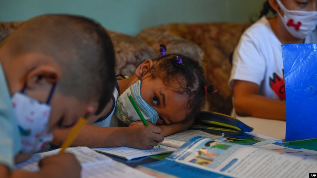 Los niños asisten a clase en un aula improvisada en una casa en el barrio de Petare, el barrio marginal más grande de Venezuela, en Caracas en medio de la pandemia del nuevo coronavirus COVID-19, el 16 de septiembre de 2020.