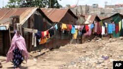 FILE - A woman walks on a street in the Korogocho slums in Kenya's capital Nairobi, April 6, 2011. 