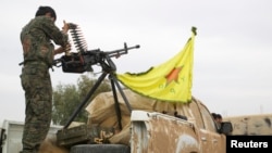 FILE - A Kurdish fighter is seen atop a pickup truck near the city of Ras al-Ain, Syria, Nov. 5, 2013.