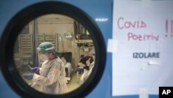 FILE - A member of the medical staff handles a syringe at the University Emergency Hospital COVID-19 section in Bucharest, Romania, Nov. 8, 2021. 