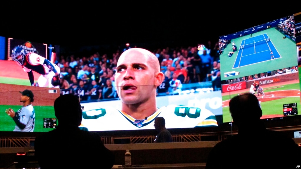 People watch video screens in the sports betting lounge at Bally's casino in Atlantic City N.J., Sept. 5, 2019. (AP Photo/Wayne Parry, FIle)