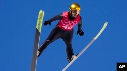 Katharina Althaus, of Germany, soars through the air during a women's normal hill ski jumping training session at the 2022 Winter Olympics, Friday, Feb. 4, 2022, in Zhangjiakou, China. (AP Photo/Andrew Medichini)