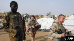 FILE - Soldiers of the Barkhane Force and the Malian army patrol in a market of Menaka, in the region of Liptako, Mali, March 21, 2019