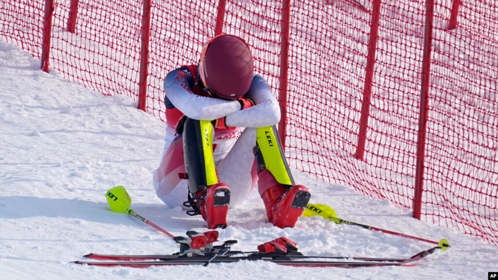 Mikaela Shiffrin sits on the side of the course after skiing out in the first run of the women's slalom at the 2022 Winter Olympics, Feb. 9, 2022, in the Yanqing district of Beijing. (AP Photo/Robert F. Bukaty)