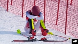 Mikaela Shiffrin sits on the side of the course after skiing out in the first run of the women's slalom at the 2022 Winter Olympics, Feb. 9, 2022, in the Yanqing district of Beijing. (AP Photo/Robert F. Bukaty)