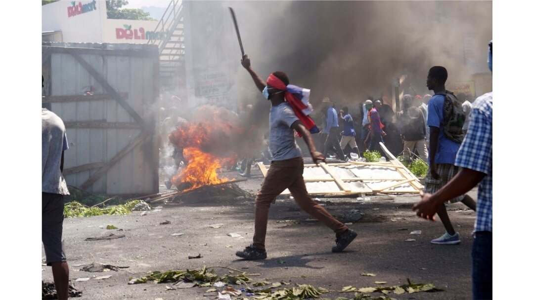 A masked protester wields a machete during a protest to demand the resignation of President Jovenel Moise in Port-au-Prince, Haiti, Sept. 27, 2019.