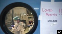 FILE - A member of the medical staff handles a syringe at the University Emergency Hospital COVID-19 section in Bucharest, Romania, Nov. 8, 2021. 