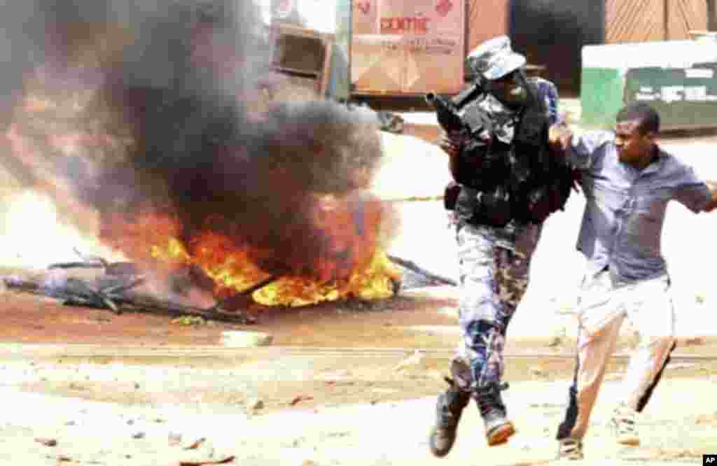 A policeman arrests a supporter of Uganda's Forum for Democratic Change (FDC) leader Kizza Besigye during a protest in Kireka suburb of the capital Kampala, April 18, 2011. Ugandan opposition leader Besigye was charged in court on Monday with engaging in
