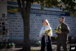 Presiden Ukraina Volodymyr Zelenskyy dan istrinya Olena meletakkan bunga di Tembok Memorial Pahlawan Ukraina yang Gugur dalam Perang Rusia-Ukraina selama perayaan Hari Kemerdekaan Ukraina di Kyiv, Ukraina, Sabtu, 24 Agustus 2024. (Foto: via AP)