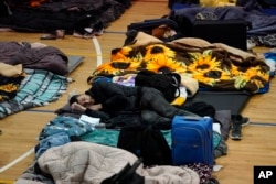 Ukrainian refugees wait in a gymnasium on Tuesday, April 5, 2022, in Tijuana, Mexico. (AP Photo/Gregory Bull)