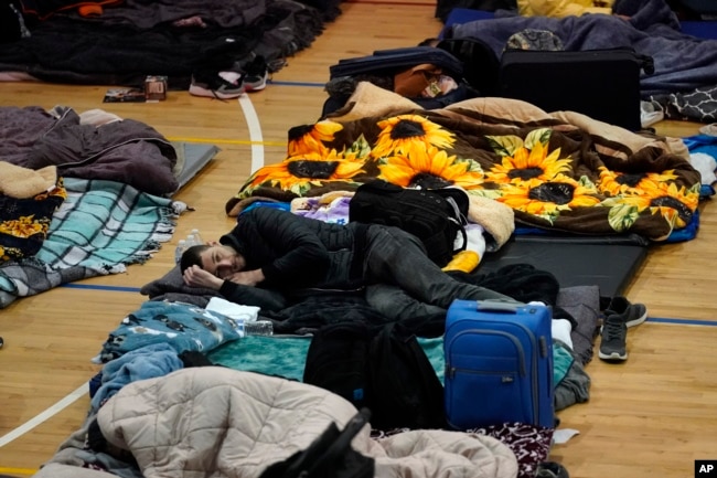 Ukrainian refugees wait in a gymnasium on Tuesday, April 5, 2022, in Tijuana, Mexico. (AP Photo/Gregory Bull)