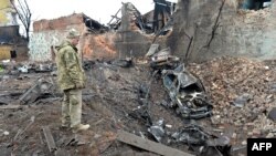 FILE - A Ukrainian serviceman looks at destructions following a shelling in Ukraine's second-biggest city of Kharkiv on March 7, 2022.