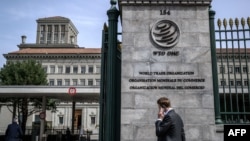 A man phones with his mobile while entering the World Trade Organization (WTO) headquarters in Geneva, Apr. 12, 2022. 