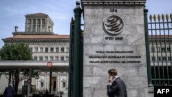 A man phones with his mobile while entering the World Trade Organization (WTO) headquarters in Geneva, Apr. 12, 2022. 