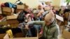 Displaced Ukrainians pick through donated clothes at an aid collection point in the western city of Lviv, April 11, 2022.