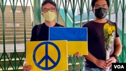 社民連外務副主席周嘉發（左）及成員余煒彬手持一束黃玫瑰、烏克蘭國旗及反戰標語參與”快閃”反戰示威，聲援烏克蘭。(美國之音/湯惠芸)