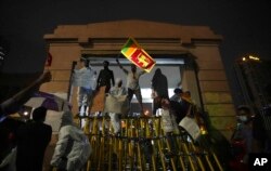 Sri Lankans shout anti-government slogans blocking the entrance to president's office during a protest in Colombo, Sri Lanka, April 11, 2022.