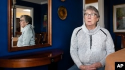 Joyce Ares sits for a portrait in the dinning room of her home on Friday, March 18, 2022, in Canby, Ore. (AP Photo/Nathan Howard)
