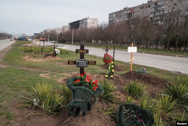 Graves of civilians killed during Ukraine-Russia war are seen next to apartment buildings in the southern port city of Mariupol, Ukraine, April 10, 2022. (REUTERS/Alexander Ermochenko)