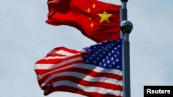 FILE - Chinese and U.S. flags flutter near The Bund in Shanghai, China July 30, 2019. 