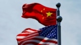 FILE - Chinese and U.S. flags flutter near The Bund, in Shanghai, China July 30, 2019. 