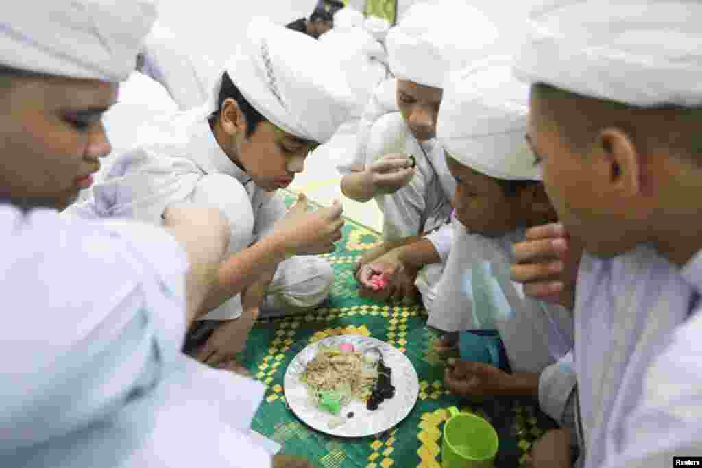 Koranic students break their fast during the holy month of Ramadan at an Islamic boarding school in Kuala Lumpur, Malaysia.