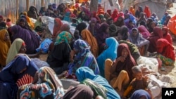 FILE - Somalis who fled drought-stricken areas sit at a makeshift camp on the outskirts of the capital Mogadishu, Somalia on Feb. 4, 2022. (AP Photo/Farah Abdi Warsameh, File)