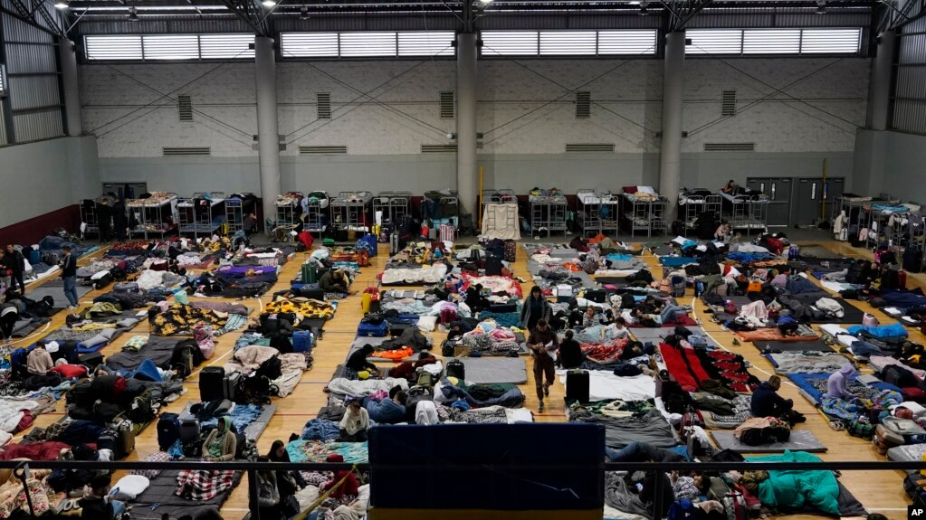 Ukrainian refugees wait in a gymnasium Tuesday, April 5, 2022, in Tijuana, Mexico. (AP Photo/Gregory Bull)