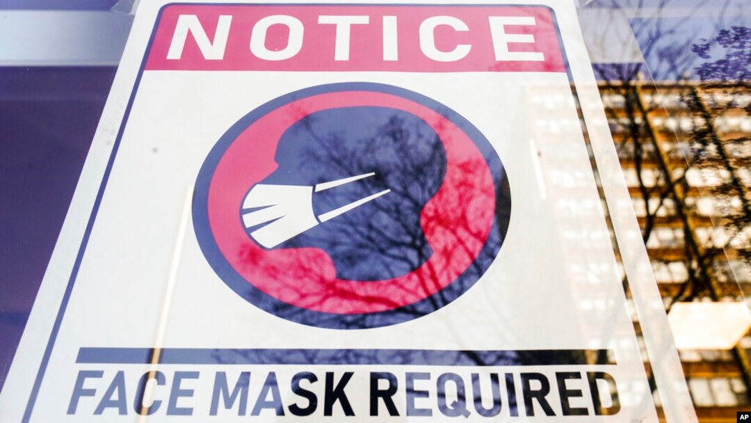 Tanda wajib mengenakan masker dipasang di depan sebuah toko di Philadelphia, 16 Februari 2022. (Ilustrasi). AS memperpanjang mandat penggunaan masker bagi penumpang pesawat dan pengguna angkutan umum.