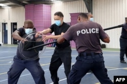 所罗门皇家警察部队2022年3月29日发布没有注明时间的照片显示，中国警察联络官（中）在训练所罗门警察格斗技术。