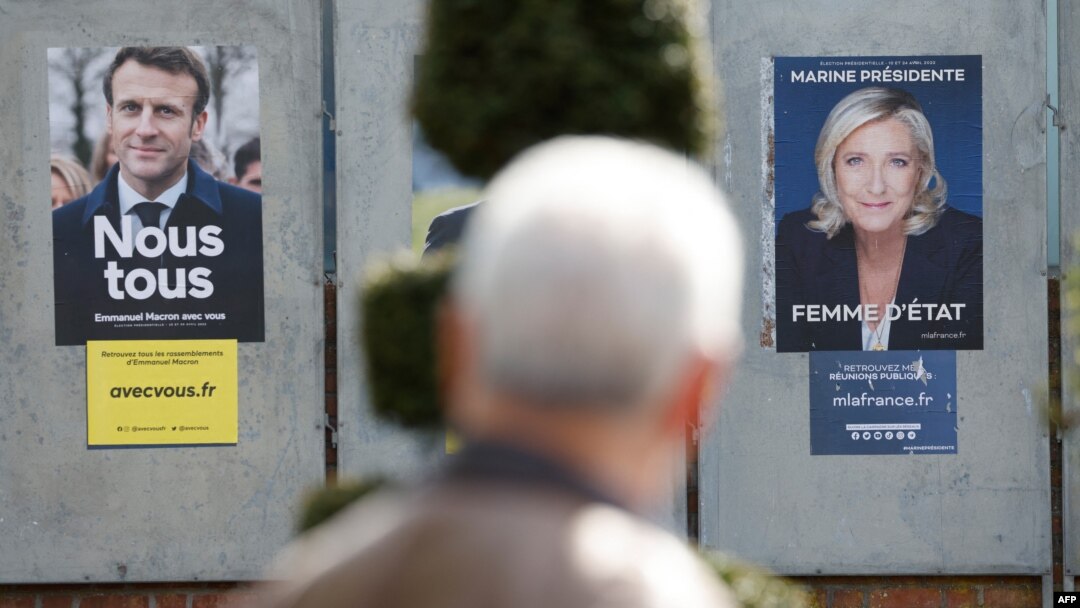 Poster kampanye calon presiden Prancis: Presiden Emmanuel Macron (kiri) dan Marine Le Pen di Denain, 11 April 2022. (Foto: Ludovic MARIN/AFP)