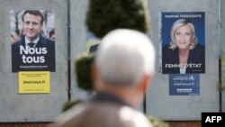 Poster kampanye calon presiden Prancis: Presiden Emmanuel Macron (kiri) dan Marine Le Pen di Denain, 11 April 2022. (Foto: Ludovic MARIN/AFP)