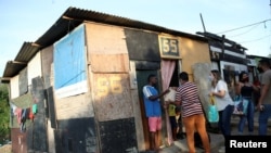 FILE - Residents of Cidade de Deus slum receive food from members of the Institute doAcao, which was produced at the Santuario de Nossa Senhora de Fatima, amid the COVID-19 outbreak, in Rio de Janeiro, Brazil, June 24, 2021.