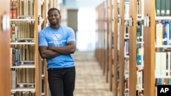 Steeve Biondolillo stands for a portrait in a library at Northwest Nazarene University in Nampa, Idaho on Friday, Oct. 7, 2022. Majoring in social work, he envisions a career working with the needy, helping to give back and nurture others. (AP Photo/Kyle Green)