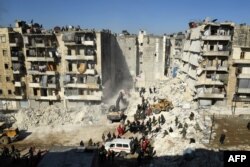 Rescuers using heavy machinery sift through the rubble of a collapsed building in the northern city of Aleppo, searching for victims and survivors days after a deadly earthquake hit Turkey and Syria, on Feb. 9, 2023.