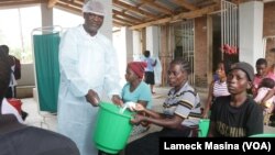 Guardians and relatives of patients receive chlorine to apply in water as a preventive measure against cholera.
