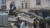 People gather as rescuers search for survivors under the rubble, following an earthquake, in rebel-held town of Jandaris, Syria Feb. 6, 2023.