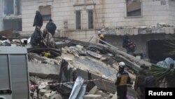 People gather as rescuers search for survivors under the rubble, following an earthquake, in rebel-held town of Jandaris, Syria Feb. 6, 2023.