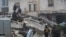 People gather as rescuers search for survivors under the rubble, following an earthquake, in rebel-held town of Jandaris, Syria Feb. 6, 2023.