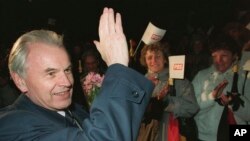 FILE - Top candidate Hans Modrow, East German prime minister, waves to the crowd at his first appearance at an election campaign event in Neubrandenburg, March 14, 1990.
