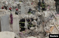 Members of the Algerian rescue team search for survivors at the site of a damaged building, in the aftermath of the earthquake in Aleppo, Syria, Feb. 8, 2023.