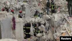 সিরিয়ার আলেপ্পোতে ভূমিকম্পের পর একটি ক্ষতিগ্রস্ত ভবনে জীবিত ব্যক্তিদের সন্ধান করছে আলজেরিয়ার উদ্ধারকারী দলের সদস্যরা। ৮ ফেব্রুয়ারী, ২০২৩।