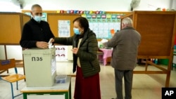 A woman casts her vote during the presidential elections in Geroskipou in south west coastal city of Paphos, Cyprus, Feb. 5, 2023.