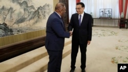 资料照片：2015年2月27日，中国国务院总理李克强（右）与时任斯里兰卡外交部长曼加拉·萨马拉维拉在北京中南海会晤前握手。（美联社照片）