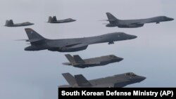 In this photo provided by South Korean Defense Ministry, U.S. Air Force B-1B bombers, F-22 fighter jets, and South Korean Air Force F-35 fighter jets, fly during a joint air drill in South Korea, Jan. 1, 2023.