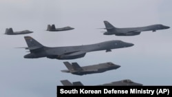FILE - In this photo provided by South Korean Defense Ministry, U.S. Air Force B-1B bombers, center, F-22 fighter jets and South Korean Air Force F-35 fighter jets, bottom, fly during a joint air drill in South Korea, Jan. 1, 2023. 