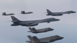 FILE - In this photo provided by South Korean Defense Ministry, U.S. Air Force B-1B bombers, center, F-22 fighter jets and South Korean Air Force F-35 fighter jets, bottom, fly during a joint air drill in South Korea, Jan. 1, 2023. 