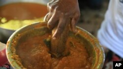 Rose Felicien, 62, mashes baked pumpkin while preparing traditional soup joumou, in the Delmas district of Port-au-Prince, Haiti, Feb. 5, 2023.
