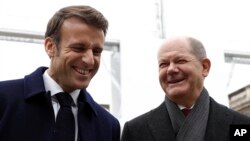 El mandatario francés Emmanuel Macron, izquierda, y el canciller alemán Olaf Scholz ríen durante una presentación de proyectos industriales franco-alemanes, el domingo 22 de enero de 2023, en el Palacio del Elíseo, en París. (Benoit Tessier, Pool vía AP)